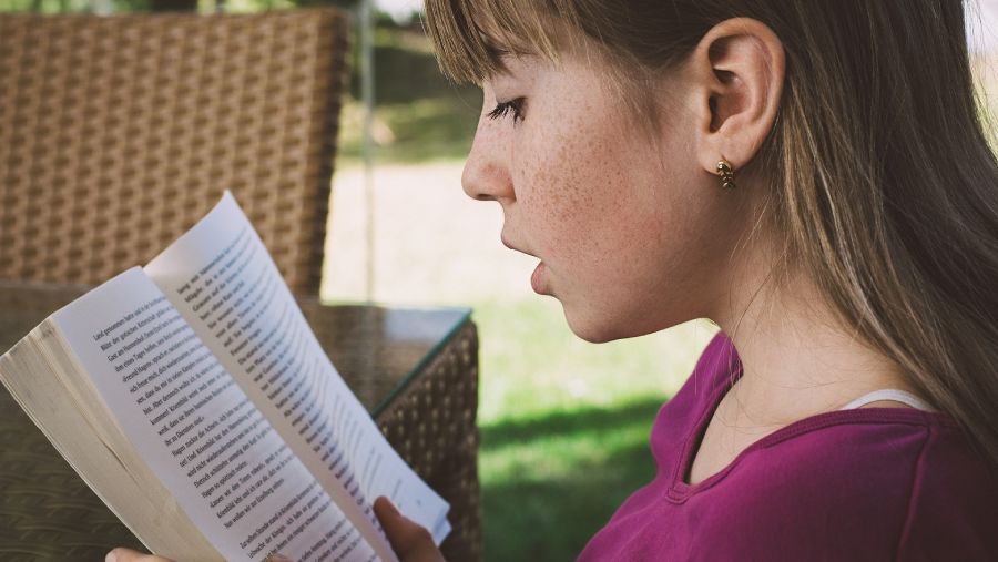 Dziewczyna czyta książkę - jakie suplementy na naukę i zapamiętywanie dla dzieci? | iZielnik.pl