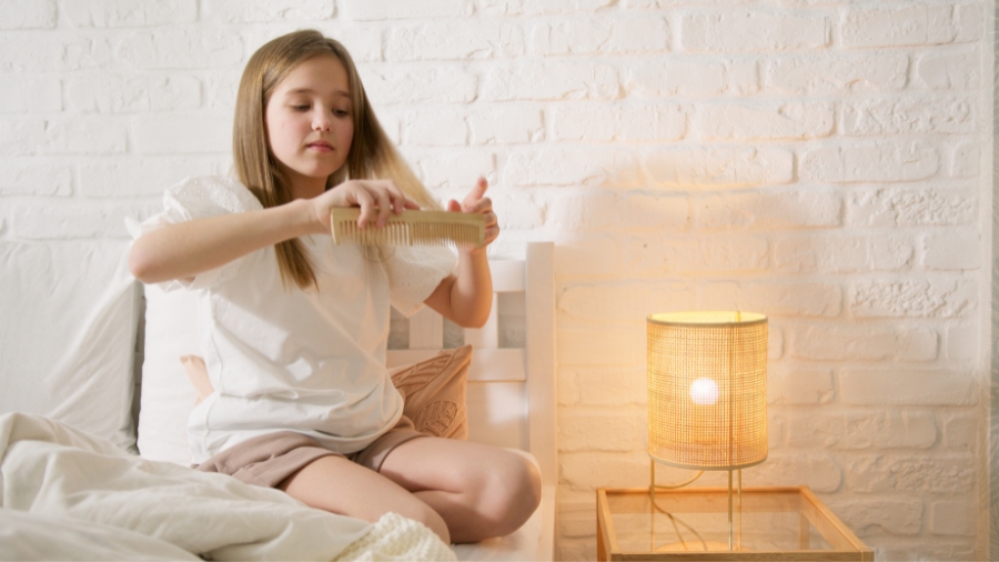 Łupież u dziecka - dziewczynka czesząca włosy